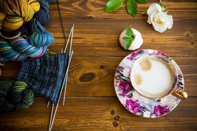 Stolik z materiałami do haftu i filiżanką kawy
